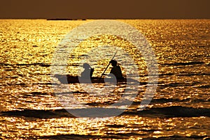 silhouette ofÂ 
Boatman rowing  in the golden sea